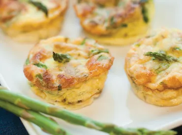 A plate of home-made mini-frittatas with asparagus, spinach, and chicken sausage