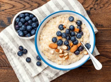 a bowl of coconut porridge with almonds and blueberries