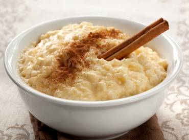 a bowl of sweetened rice pudding with cinnamon on top