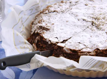 a deep dark chocolate cake with confectioner's sugar on top