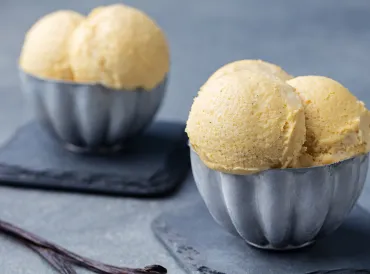 Homemade French Vanilla Ice Cream scooped into two blue bowls.