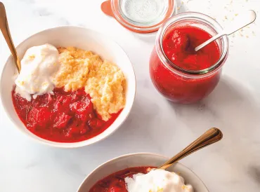 a bowl of cooked berries with cornmeal polenta and ice cream