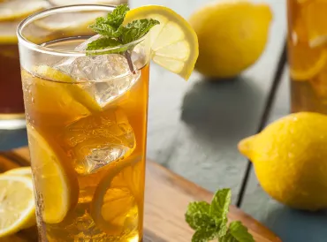 Freshly made iced tea in a glass with lemon.