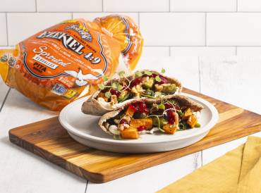 pita bread stuffed with cranberries and vegetables on cutting board