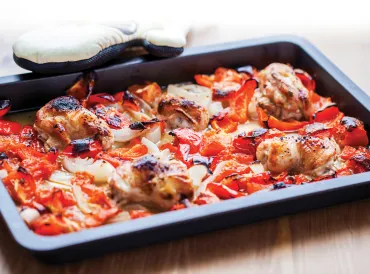 Ratatouille Sheet Pan Chicken just pulled out of the oven next to oven mitt.
