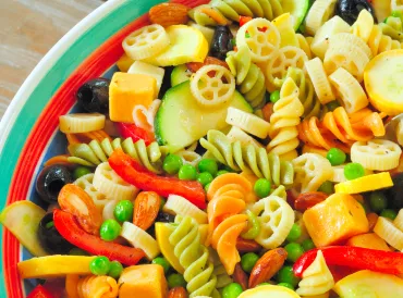 a bowl of pasta tossed with summer veggies