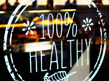 a restaurant with a sticker in the window that says "100% healthy"