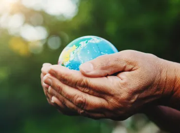 a senior woman cradling the world in her hands
