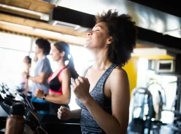 Happy group of fit people training in gym.