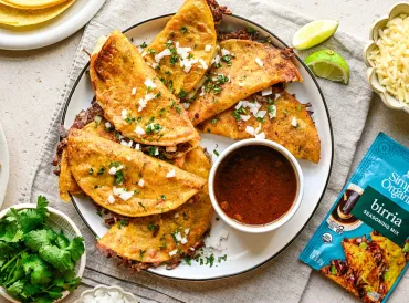 Birria Tacos on plate with dipping sauce and seasoning packet