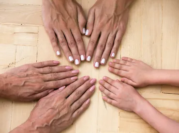 different generations of a family touching hands