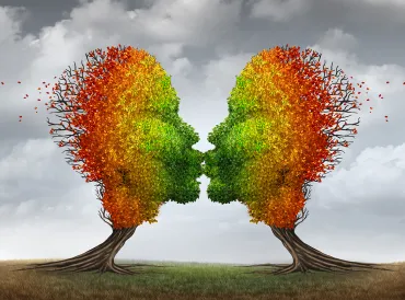 two trees with autumn leaves giving each other a smooch