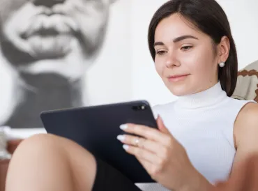 Woman with brunette hair and a white shirt communicating via email.