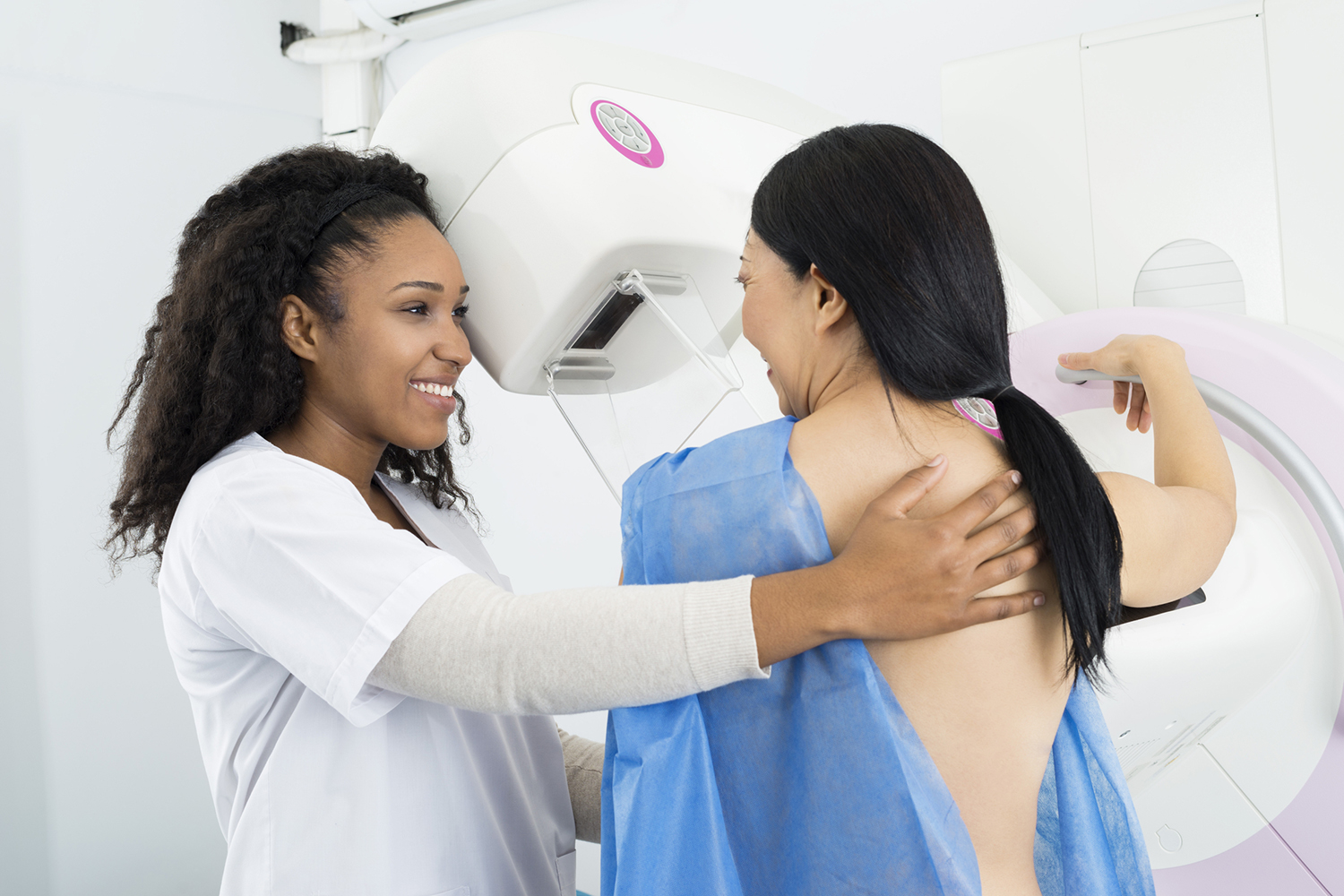 a helpful nurse getting a woman ready for her mammogram
