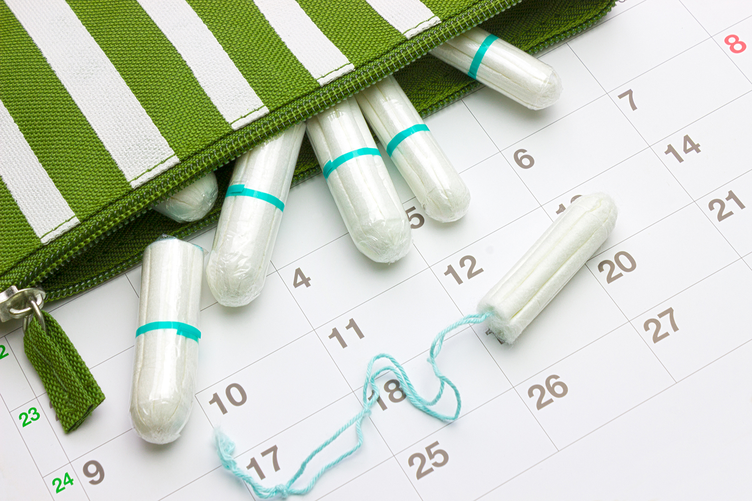 a zipper-case full of tampons resting on a calendar