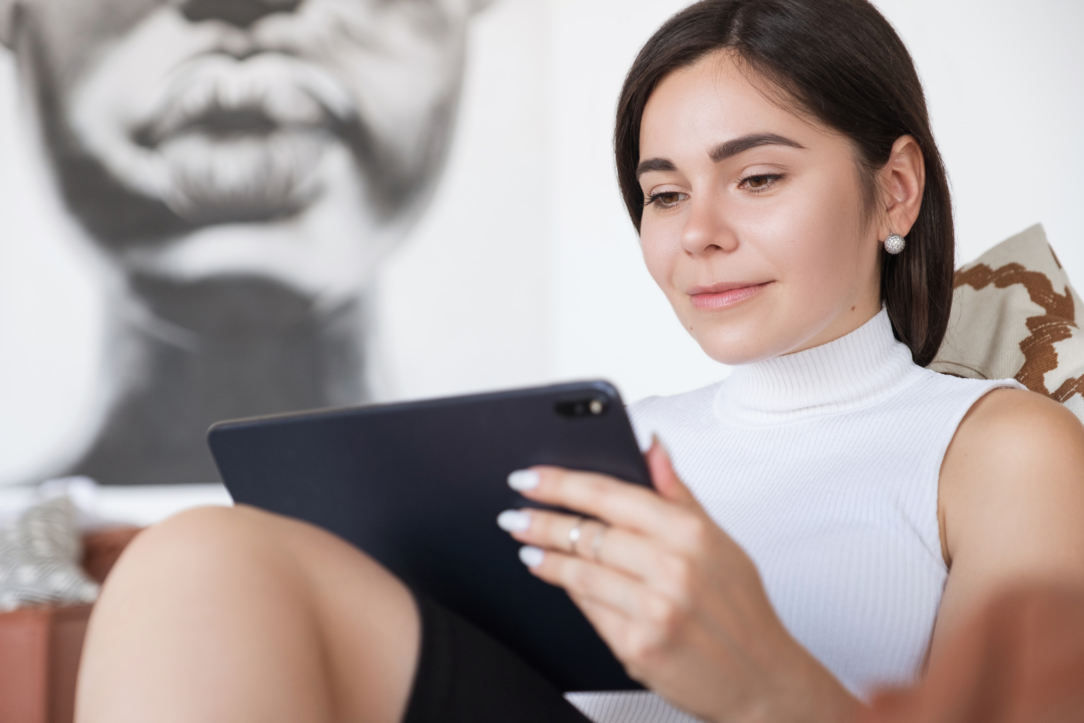 Woman with brunette hair and a white shirt communicating via email.